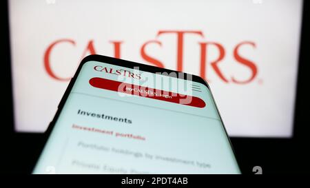 Smartphone con pagina web del California state Teachers Retirement System (CalSTRS) sullo schermo davanti al logo. Messa a fuoco in alto a sinistra del display del telefono. Foto Stock