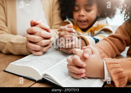 La Bibbia, le mani o la mamma pregano insieme con i figli fratelli per pregare, sostenere o sperare nel cristianesimo. Educazione dei bambini, culto della famiglia o donna Foto Stock