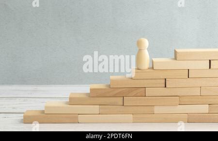 la silhouette di un lavoratore di ufficio con una valigia sale le scale. ingranaggi su uno sfondo di legno. Foto Stock