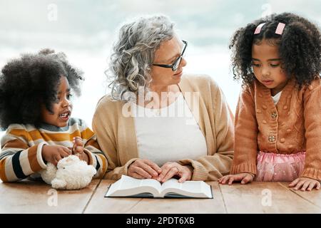 Bibbia, libro di lettura o nonna con i bambini per culto, sostegno o speranza nel cristianesimo per l'istruzione. Figli fratelli, nonna o donna anziana Foto Stock