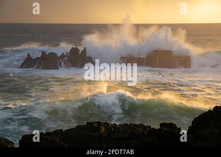 Onde dell'Oceano Atlantico che si infrangono sulle rocce a Campos de Lapias al tramonto, Cascais, Regione di Lisbona, Portogallo, Europa Foto Stock