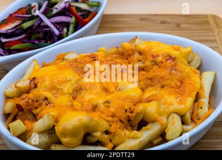 Cheesy chips - patatine fritte con formaggio fuso e grigliato Foto Stock