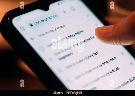 Primo piano vista posteriore della donna che cerca come fare soldi online su uno smartphone generico Foto Stock