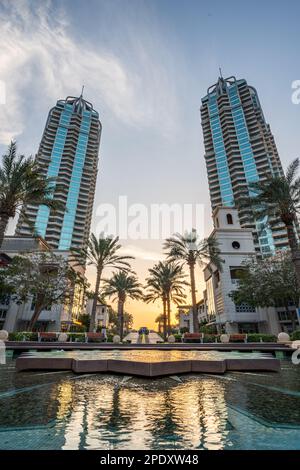 Una splendida immagine di un maestoso corpo d'acqua situato vicino ai torreggianti edifici di Dubai Foto Stock