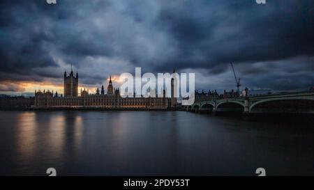 Un tramonto nuvoloso e scuro a Londra sopra le Houses of Parliament e Westminster Bridge. Foto Stock