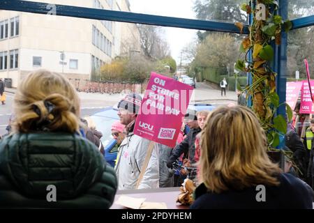 Protesta vista da un bar. I membri DI UCU marciano verso il basso a College Green. I conferenzieri dell'Università di Bristol continuano ad agire in sciopero il giorno del budget nella loro lotta per le pensioni, la parità di retribuzione, i carichi di lavoro ragionevoli e la fine dei contratti precari. I lavoratori sono sostenuti dalla UCU o University College Union, che anticipano un'alta svolta sulle linee di picket. La retribuzione stagnante, con l'aumento del costo della vita, aumenta l'ansia del personale universitario. Credit: JMF News/Alamy Live News Foto Stock