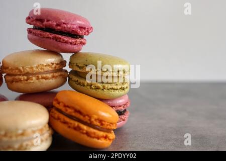 Un mucchio di coloratissimi macaron francesi su sfondo neutro. Foto Stock
