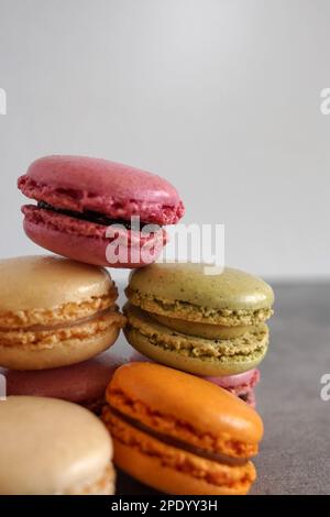Un mucchio di coloratissimi macaron francesi su sfondo neutro. Foto Stock