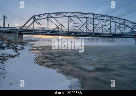 Alba invernale sul fiume Bow e un ponte a Cochrane, Alberta, Canada Foto Stock