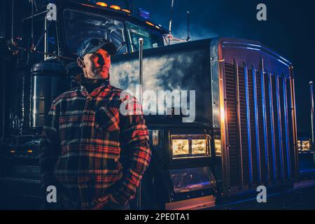 Tema trasporti per impieghi gravosi. Conducente semi-camion commerciale. Caucasico Trucker nel suo 40s. Foto Stock