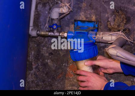 l'idraulico installa un filtro dell'acqua nella cantina situata Foto Stock