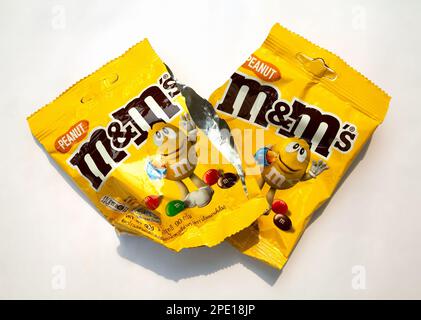 Ho Chi Minh City, Vietnam - 3 marzo 2023: 2 m&m's caramelle al cioccolato di arachidi vuote confezionatrici accartocciati isolate su bianco. Popolare confezione caramelle con un br Foto Stock