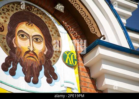 Khabarovsk, Russia - 23 luglio 2014: Icona contemporanea del mosaico di Gesù Cristo in pietra su una chiesa ortodossa. Faccia sacra sulla parete immagine colorata primo piano Foto Stock