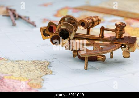 sestante nautico con ottica, bussola e righello giacente su carta mappa del mondo Foto Stock