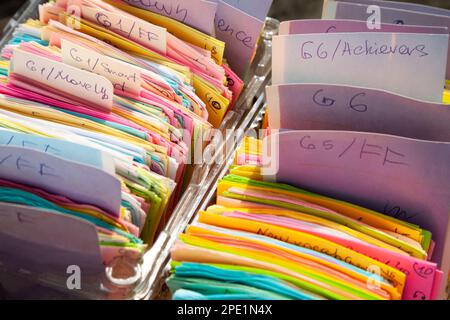 Una scheda di indice colorata organizzata in righe e memorizzata in scatole. Note scritte a mano su carta quadre e classificate Foto Stock