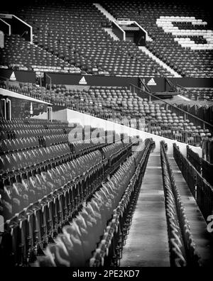 Immagine in bianco e nero di Row upon Row of Empty Seats a Old Trafford, sede del Manchester United Foto Stock