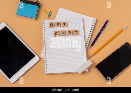 Lavora e studia il background con l'aiuto di un bot chatGPT. Parole in lettere di legno. Vista da tavolo con spazio di copia del notebook aperto. Chat GPT per lavorare e creare. Ucraina, Kiev - 21 febbraio 2023 Foto Stock