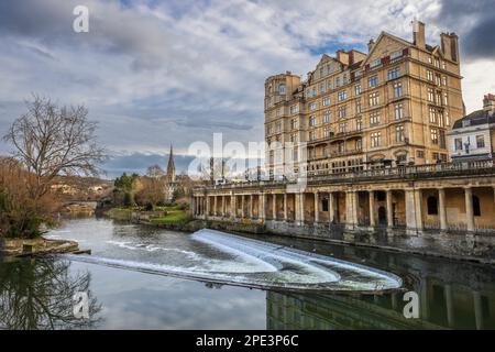 L'Empire Hotel e Weir sul fiume Avon con la chiesa di San Giovanni sullo sfondo, Bath, Somerset Foto Stock