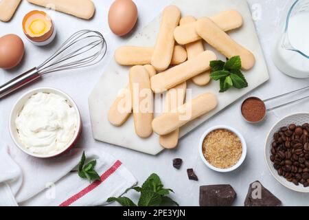 Composizione di posa piatta con ingredienti per tiramisù su tavolo grigio chiaro Foto Stock