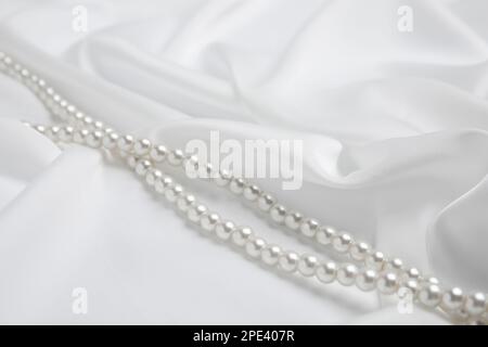 Belle perle su delicata seta bianca, primo piano Foto Stock
