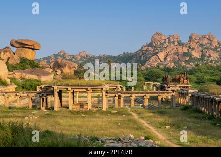 Rovine del vecchio bazar e del lago Pushkarni di fronte al tempio Krishna in Hampi. Hampi, la capitale dell'impero Vijayanagar è un sito patrimonio dell'umanità dell'UNESCO Foto Stock