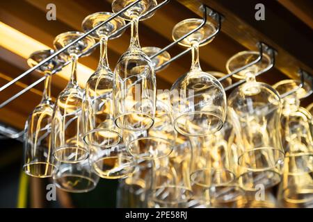 i bicchieri da vino puliti appendono al bar. Vetro, utensili, oggetti. Foto Stock