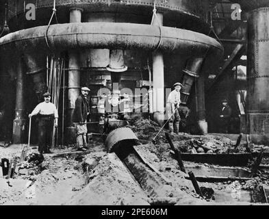 Il fondo di un altoforno, c1933. Un altoforno è un tipo di forno metallurgico usato per la fusione per produrre metalli industriali, generalmente ghisa, ma anche altri come piombo o rame. L'altoforno si riferisce alla combustione dell'aria che viene alimentata al di sopra della pressione atmosferica. Foto Stock