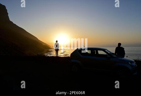 Due persone si godono il tramonto a Kogel Bay, Capo Occidentale, Sud Africa Foto Stock