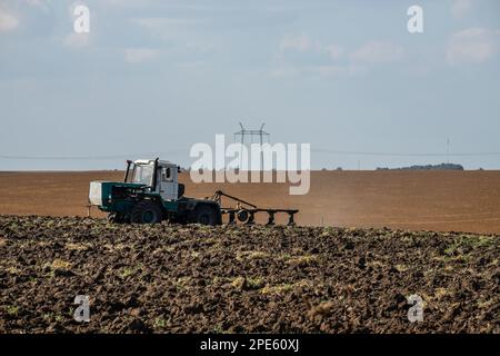 L'agricoltore nel trattore la preparazione di terra con il seedbed coltivatore. Foto Stock