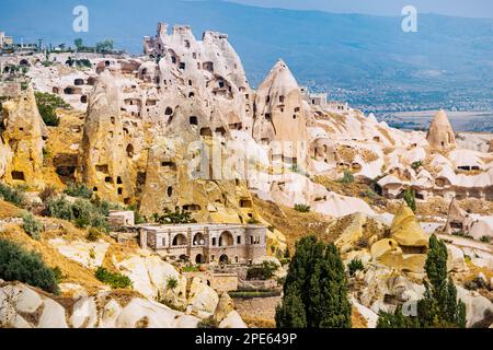 Alberghi e case scavate nelle rocce di morbido tufo vulcanico in Cappadocia - una delle meraviglie del mondo in Turchia. Foto Stock