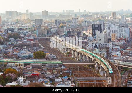 Uno Shinkansen, il famoso bullet train giapponese, passa attraverso l'area urbana di Tokyo Foto Stock