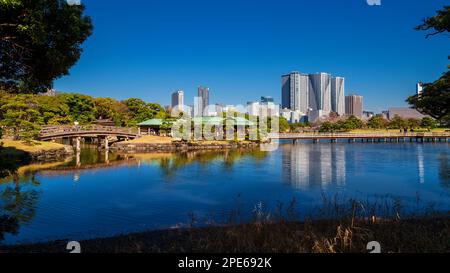 Il Giappone tra tradizione e modernità. Tokyo Hamarikyu Garden con vecchio padiglione e bidet di legno con grattacieli moderni sullo sfondo Foto Stock