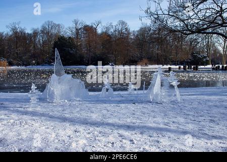 Karlsruhe, Germania - 12 febbraio 2021: Scultura di ghiaccio accanto a uno stagno congelato in una giornata invernale nei giardini di Karlsruhe in Germania. Foto Stock