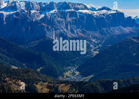 La città turistica di Selva Gardena, vista dalla cima del Seceda, sullo sfondo le vette innevate del massiccio del Sella, Val Gardena, Dolomiti Foto Stock