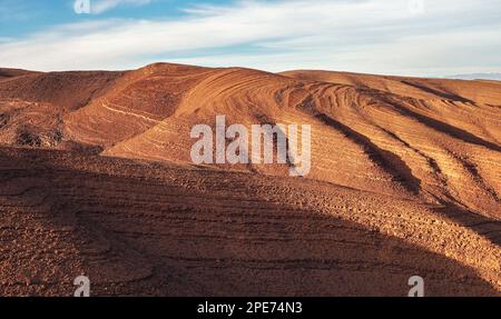 Panorama delle colline con regolare modello di terreno marrone in Tizi'n-Tinififft passo Ouaourmas Marocco, cielo blu sopra Foto Stock