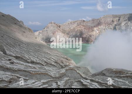 Lago vulcanico acido di colore turchese-verde con vapore che sale dalla sua bocca, Monte Ijen, Giava Orientale, Indonesia Foto Stock