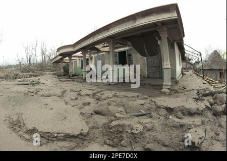 Strada coperta di cenere, alberi morti e case danneggiate dalla recente eruzione vulcanica, Kepuharjo, Monte Merapi, Giava Centrale, Indonesia, Novembre Foto Stock