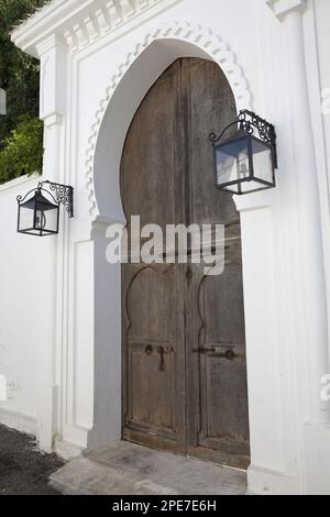 Porta di legno e lanterne in una strada costiera della città, Tangeri, Marocco Foto Stock