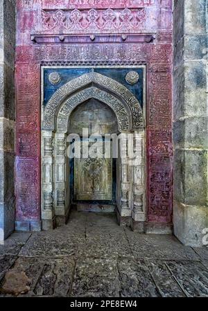 Calligrafia araba che circonda il Mihrab all'interno della tomba di Isa Khan Foto Stock