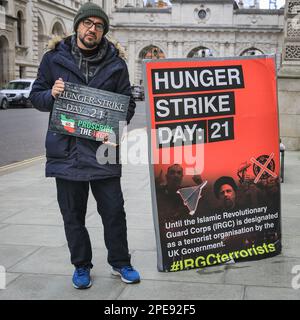 Londra, Regno Unito. 15th Mar, 2023. Vahid Beheshti, che dichiara di essere un giornalista, è visto il giorno 21 del suo sciopero della fame al di fuori dell'Ufficio degli Esteri britannico a Westminster. Beheshti chiede che l'IRGC (corpo della Guardia rivoluzionaria Islamica) sia inserito nella lista delle organizzazioni terroristiche internazionali del Regno Unito. L'IRGC, un ramo dell'esercito iraniano, è considerato sempre più oppressivo e considerato un'organizzazione terroristica dagli Stati Uniti dal 2019, mentre l'UE ha recentemente approvato un emendamento che chiede agli stati membri di fare simili. Credit: Imageplotter/Alamy Live News Foto Stock