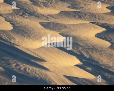 La luce del tramonto evidenzia i modelli di neve scottata sul lago dell'Alaska centro-meridionale. Foto Stock