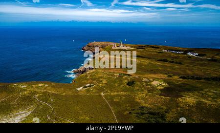 Scogliere sulla costa atlantica con l'antico faro a Cap Frehel in Bretagna, Francia; Phare du Cap Frehel Foto Stock