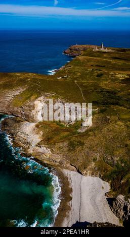 Scogliere sulla costa atlantica con l'antico faro a Cap Frehel in Bretagna, Francia; Phare du Cap Frehel Foto Stock