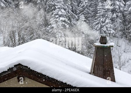 camino in rame su tetto innevato Foto Stock