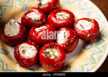 pomodori ciliegini ripieni di formaggio e spezie su un piatto. Foto Stock