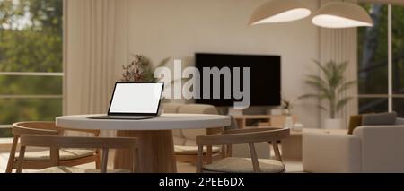 Mockup per computer portatile su un tavolo da pranzo minimal in un soggiorno confortevole e contemporaneo con Smart TV su un mobile TV, un comodo divano e eleganti pendenti. 3d giri Foto Stock