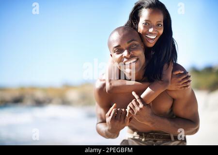 Godendo la loro vacanza al sole insieme. Un'eccitata coppia afro-americana che si gode la spiaggia insieme. Foto Stock