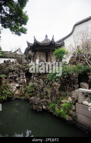 Un idilliaco giardino asiatico scena con un tranquillo ruscello che si snoda attraverso la vegetazione lussureggiante e terreno roccioso Foto Stock