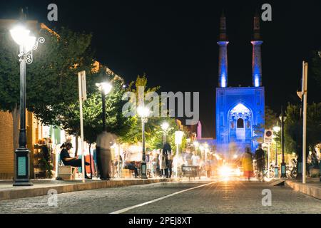 Yazd, Iran - 10th giugno, 2022: Moschea Hazireh blu durante la notte a Yazd, Iran. Scena di strada di Blue hour con pedoni e traffico Foto Stock