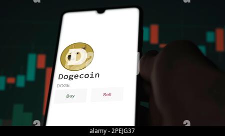 Marzo 11 2023 Londra UK. Un investitore che analizza la moneta dogecoin sullo schermo. Un telefono mostra i prezzi del cripto per investire in DOGE Foto Stock